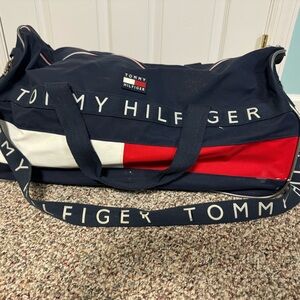 Vintage 90’s distressed Tommy Hilfiger duffel bag. Handle has 2 small holes.